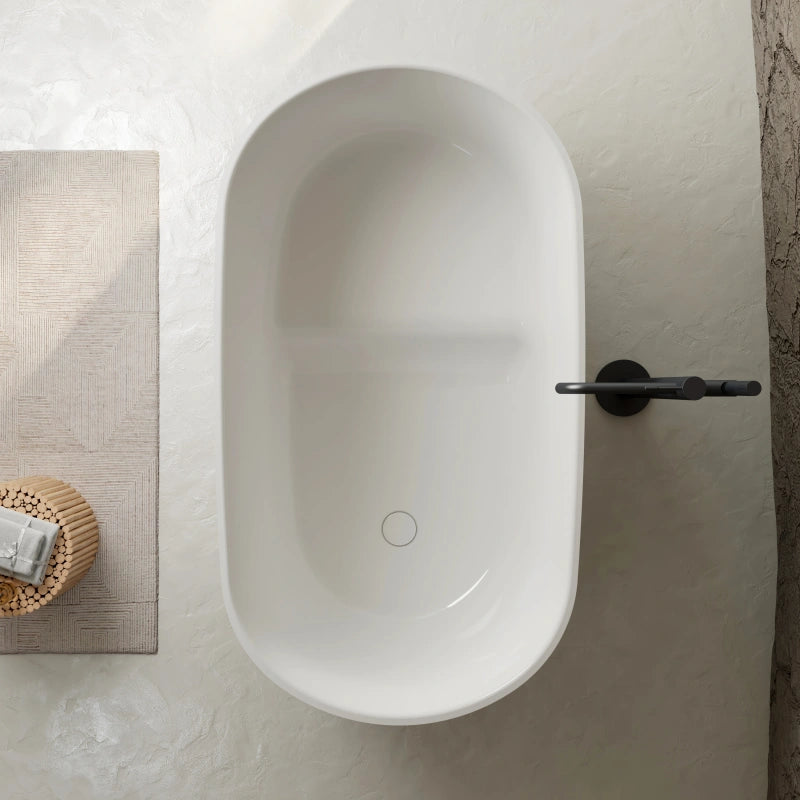 Glossy white freestanding soaking tub with hidden overflow and pop-up drain