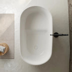 Glossy white freestanding soaking tub with hidden overflow and pop-up drain